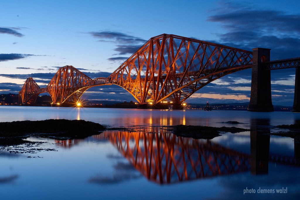 Forth Bridge in der blauen Stunde, gespiegelt im Wasser, Schottland