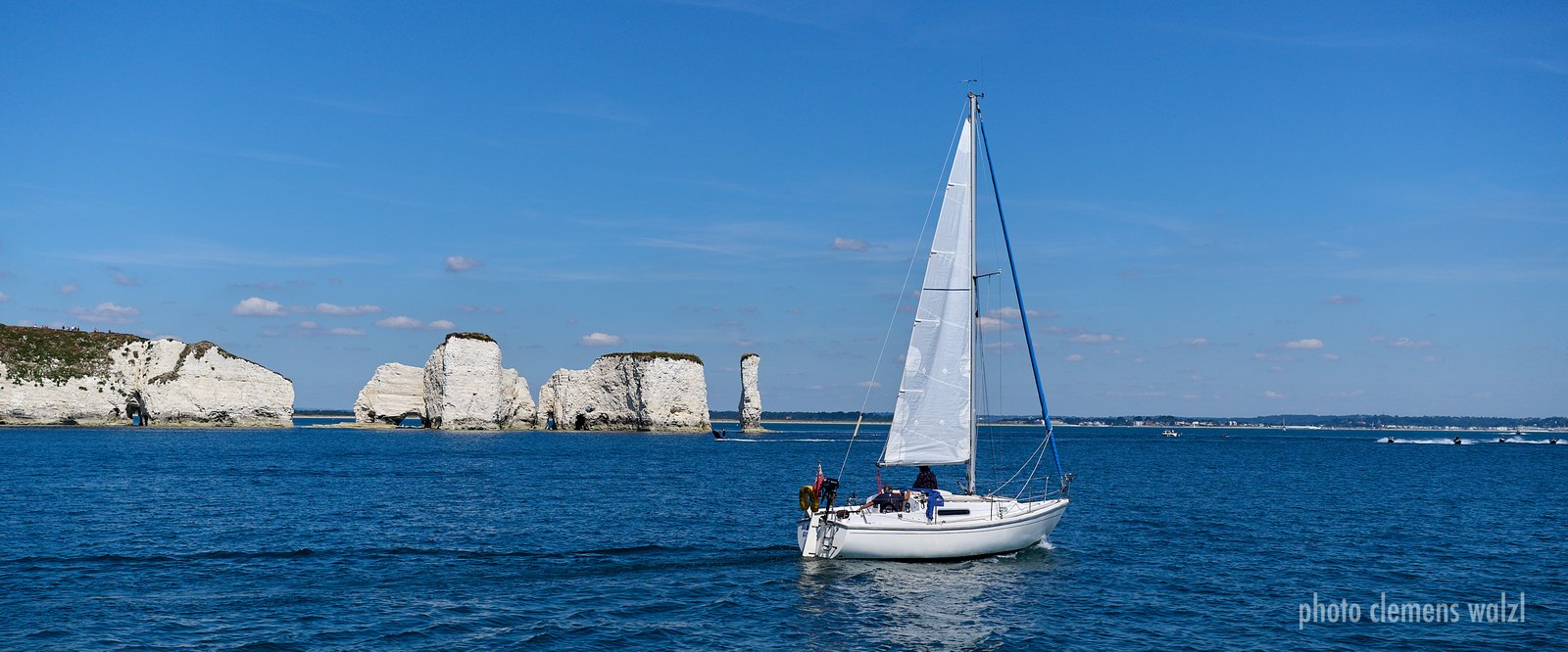 Weites Panorama der Jurassic Coast mit Segelboot vor den Kreidefelsen der Old Harry Rocks